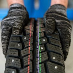 new-tyre-for-car-or-lorry-held-by-worker-of-contem-ULX589M.jpg